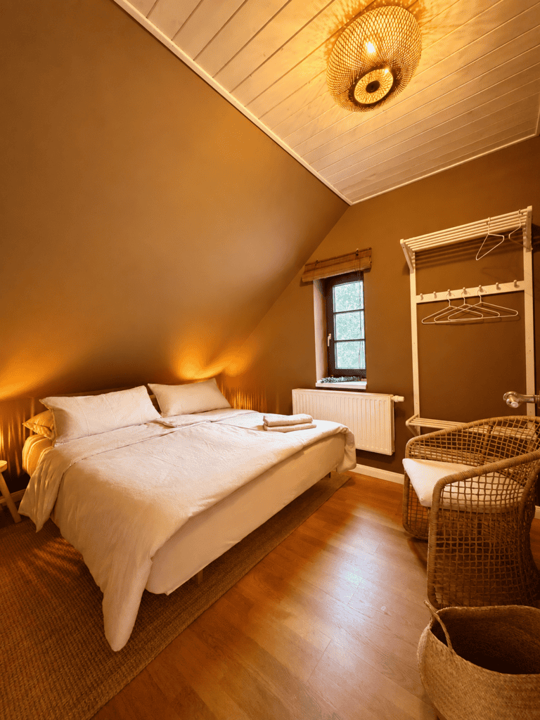 Bett in Zimmer 1 im Abendlicht mit Lampen an
