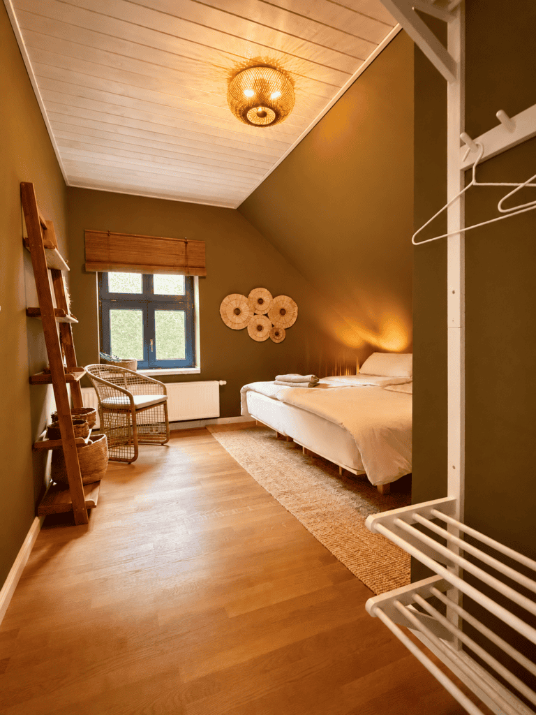 Garderobe, Regal und Bett mit Lampe im Abendlicht in Zimmer 5