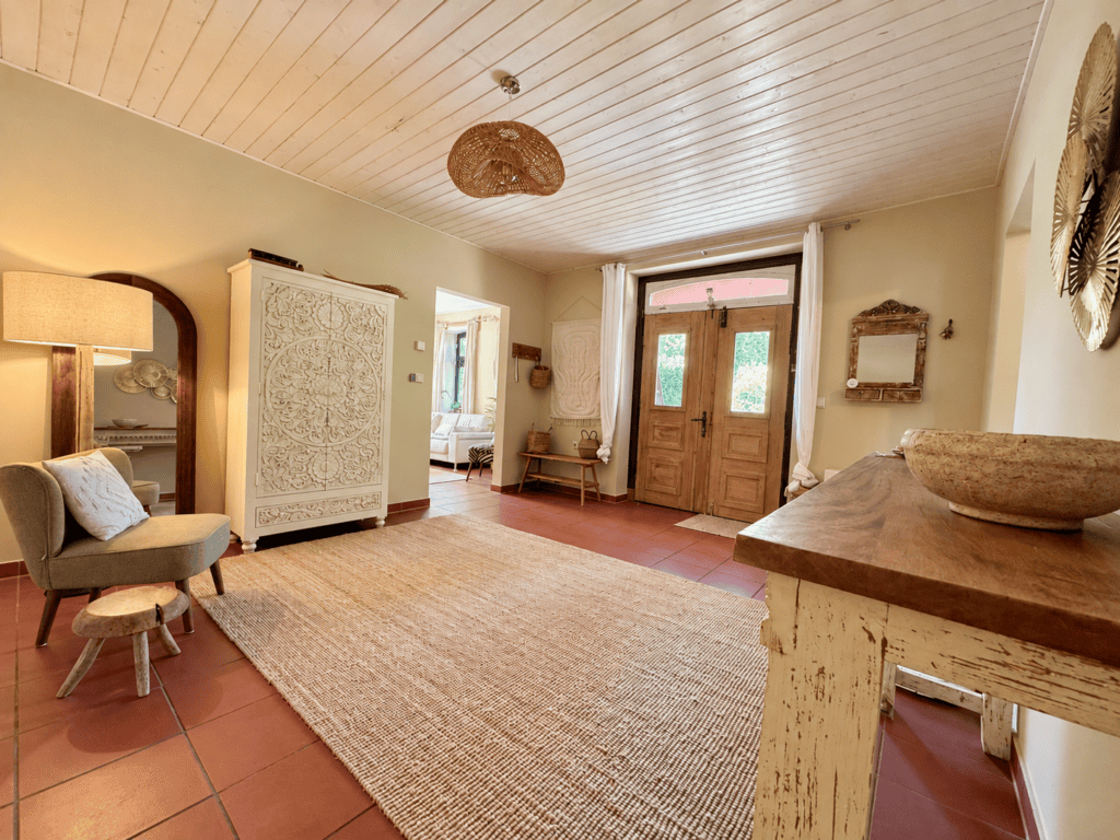 Eingangsbereich Gästehaus mit Sessel, Schrank und Schuhbänken